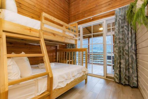 1 dormitorio con literas en una cabaña de madera en Villa Panorama, en La Lomota