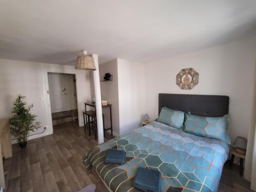 um quarto com uma cama com um edredão azul em Chambre indépendante Au Relais Normand em Cormeilles