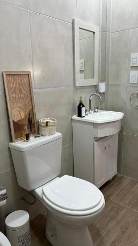 La salle de bains est pourvue de toilettes blanches et d'un lavabo. dans l'établissement Departamento complejo Vita, à Concepción del Uruguay