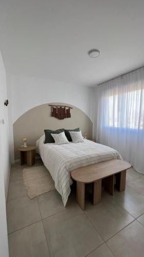 a bedroom with a large bed and a wooden bench at Departamento complejo Vita in Concepción del Uruguay