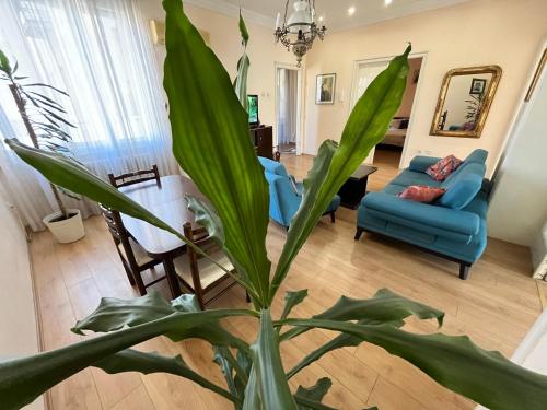 a living room with a blue couch and a plant at Terazije Square Lux Apartment in Belgrade