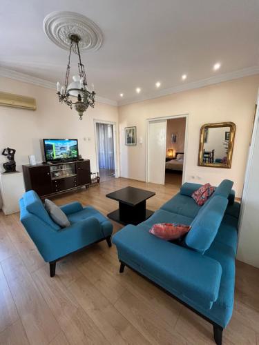 a living room with two blue couches and a television at Terazije Square Lux Apartment in Belgrade