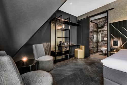 a hotel room with a bed and a bathroom at Le Marin Hotel Rotterdam City - Handwritten Collection in Rotterdam