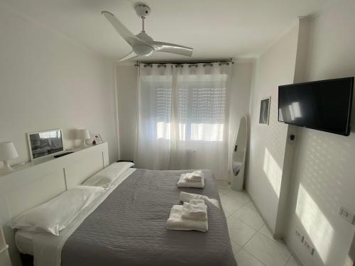 una camera bianca con un letto con due asciugamani di VESUCHARME Flat a Napoli