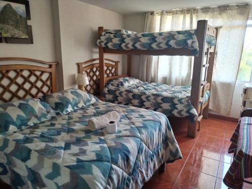 1 dormitorio con 2 camas y 1 litera en Hostal Turístico El Cajamarquez, en Lima