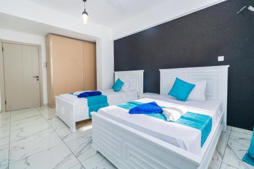 two beds in a room with blue and white at Luxury 3br Ensuite Apt in Prestigious Nyali in Mombasa