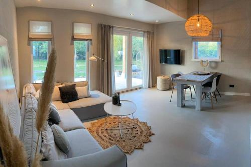 a living room with a couch and a table at Stijlvol huisje met veranda! Tuynloodz C in Beers