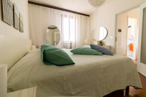 デセンツァーノ・デル・ガルダにあるLa Chicca sui Tetti Centro&Lago By Case al Lagoの緑の枕が付いた大きなベッドのある寝室