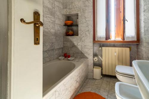 デセンツァーノ・デル・ガルダにあるLa Chicca sui Tetti Centro&Lago By Case al Lagoの浴槽、トイレ、洗面台を備えたバスルーム