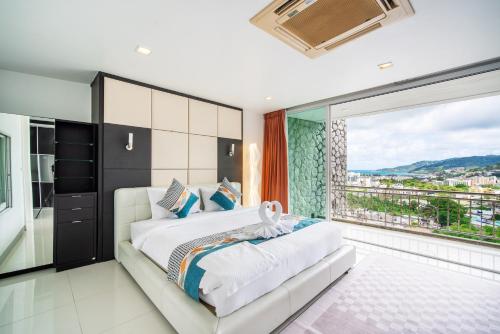 1 dormitorio con cama grande y ventana grande en patong villa2：四卧泳池别墅/两个海景房/近班赞酒吧街, en Patong Beach