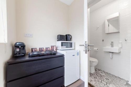 a kitchen with a microwave on top of a refrigerator at Spacious sleeps 3 Ensuite Room In twickenham TW7 in Isleworth
