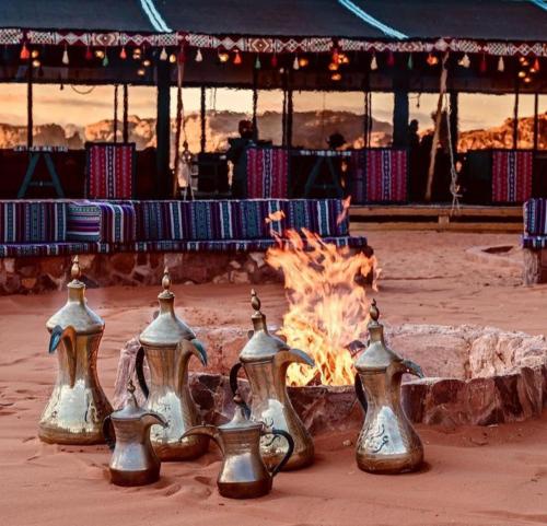 a group of pots and pans sitting next to a fire at Wadi Rum Calma camp in Aqaba