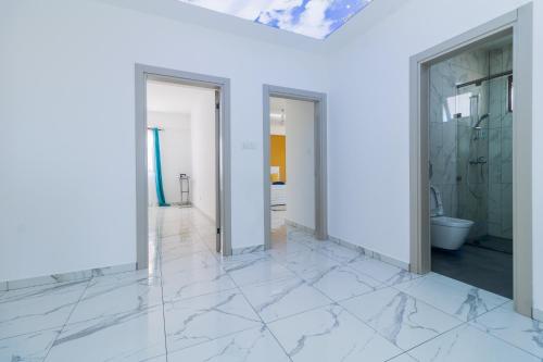 a bathroom with white marble floors and walls at Luxury 3br Ensuite Apt in Prestigious Nyali in Mombasa