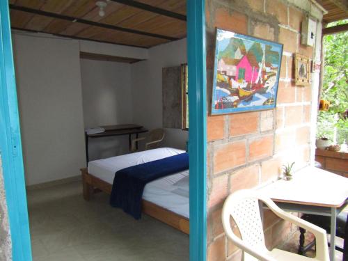 ein Schlafzimmer mit einem Bett und einer Ziegelwand in der Unterkunft Alojamiento rural pájaros y flores in Los Andes