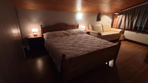 a bedroom with a bed and a couch and a chair at Chalet Rezia in Savognin