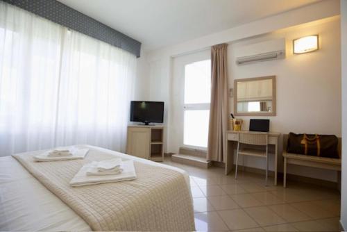 a bedroom with a bed and a desk and a television at Hotel Elite in Cervia