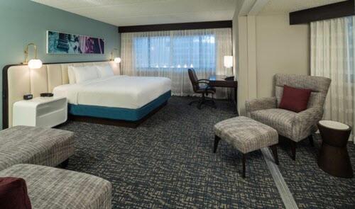 a hotel room with a bed and a desk and chairs at DoubleTree by Hilton Austin Northwest - Arboretum in Austin