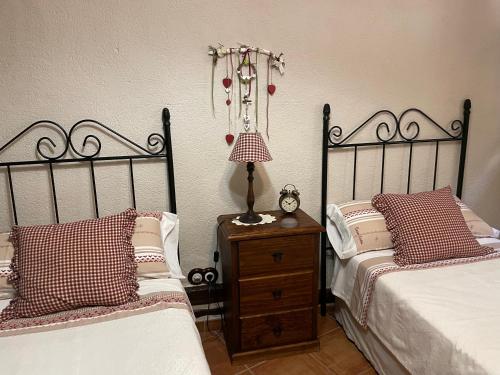 a bedroom with two beds and a table with a lamp at Casa Lidia - Antigua Posada Real in Valderrobres
