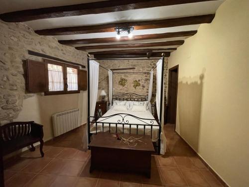 a bedroom with a bed in a stone wall at Casa Lidia - Antigua Posada Real in Valderrobres