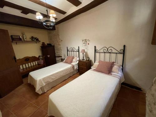 a bedroom with two beds with white sheets at Casa Lidia - Antigua Posada Real in Valderrobres