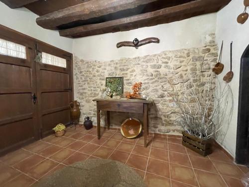 a room with a wooden table and a stone wall at Casa Lidia - Antigua Posada Real in Valderrobres