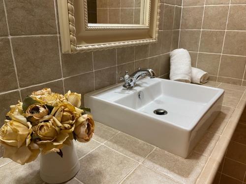 a bathroom with a sink and a vase of flowers at Casa Lidia - Antigua Posada Real in Valderrobres