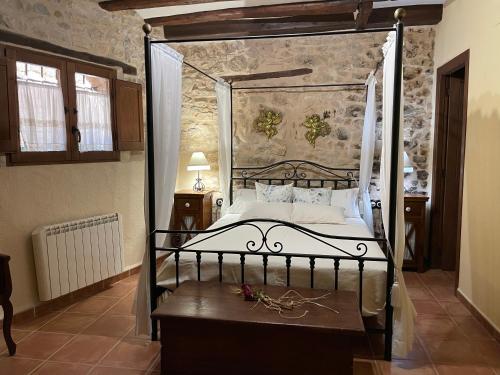 a bedroom with a bed with a metal canopy at Casa Lidia - Antigua Posada Real in Valderrobres