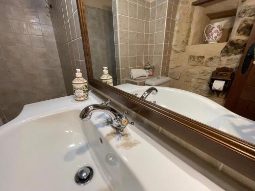 a bathroom with a bath tub and a mirror at Casa Lidia - Antigua Posada Real in Valderrobres