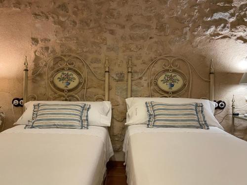 two beds sitting next to each other in a bedroom at Casa Lidia - Antigua Posada Real in Valderrobres