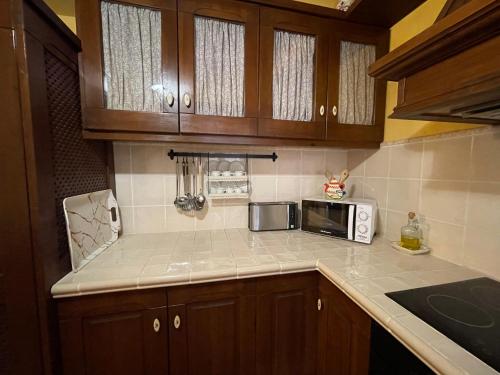a kitchen with wooden cabinets and a microwave at Casa Lidia - Antigua Posada Real in Valderrobres