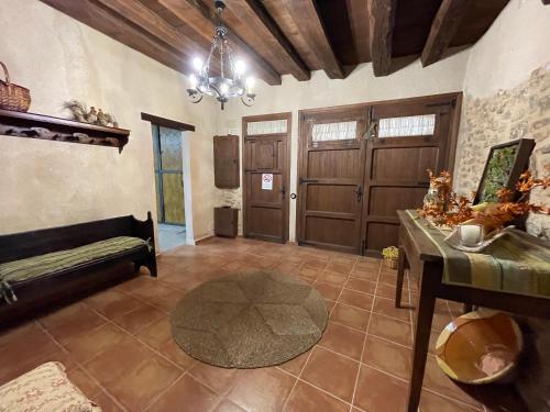 a living room with two brown doors and a table at Casa Lidia - Antigua Posada Real in Valderrobres