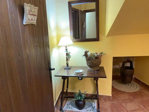 a hallway with a table with a lamp and a mirror at Casa Lidia - Antigua Posada Real in Valderrobres