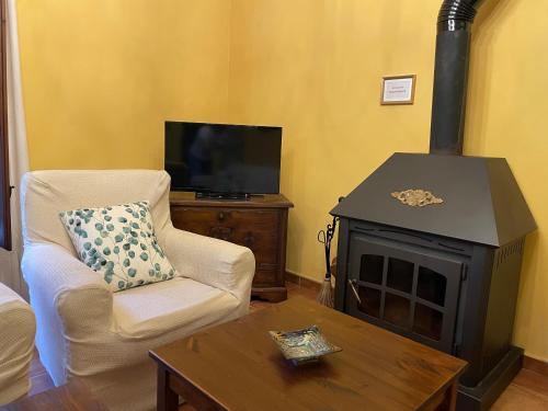 a living room with a chair and a stove at Casa Lidia - Antigua Posada Real in Valderrobres