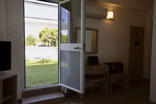 a room with a sliding glass door with a view of a yard at Hotel Elite in Cervia