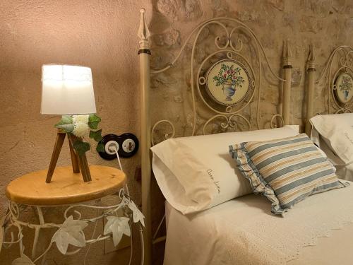a bedroom with a bed and a table with a lamp at Casa Lidia - Antigua Posada Real in Valderrobres
