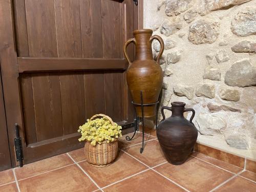 two vases sitting on a floor next to a stone wall at Casa Lidia - Antigua Posada Real in Valderrobres