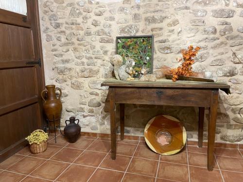 a stone room with a wooden table with a bowl under it at Casa Lidia - Antigua Posada Real in Valderrobres