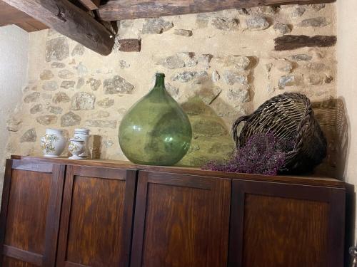 a green vase sitting on top of a wooden cabinet at Casa Lidia - Antigua Posada Real in Valderrobres