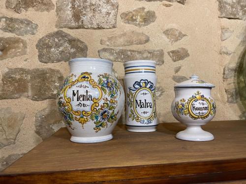 three vases sitting on top of a wooden shelf at Casa Lidia - Antigua Posada Real in Valderrobres