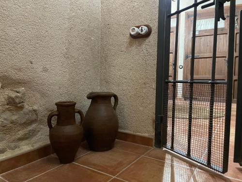 two vases sitting on the floor next to a wall at Casa Lidia - Antigua Posada Real in Valderrobres