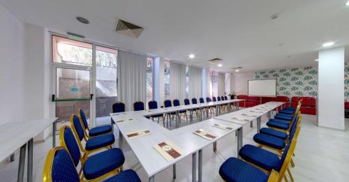 a conference room with tables and blue chairs at SPA Hotel Sirius Beach - FREE SPA access in St. St. Constantine and Helena