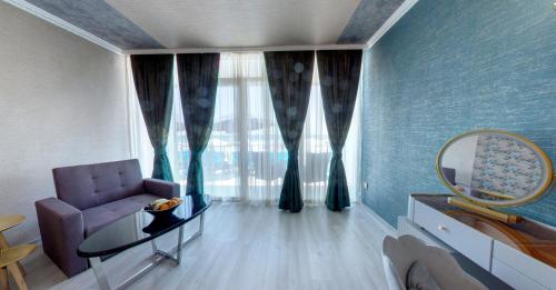 a living room with a purple couch and a mirror at SPA Hotel Sirius Beach - FREE SPA access in St. St. Constantine and Helena