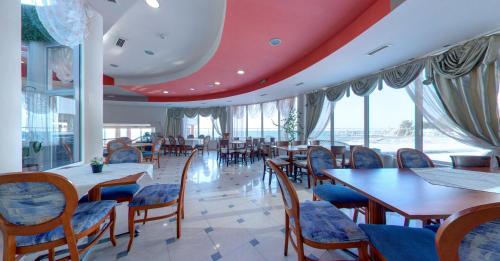 a restaurant with tables and chairs and a red ceiling at SPA Hotel Sirius Beach - FREE SPA access in St. St. Constantine and Helena