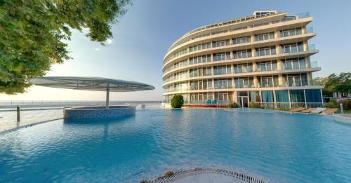 a swimming pool in front of a building at SPA Hotel Sirius Beach - FREE SPA access in St. St. Constantine and Helena