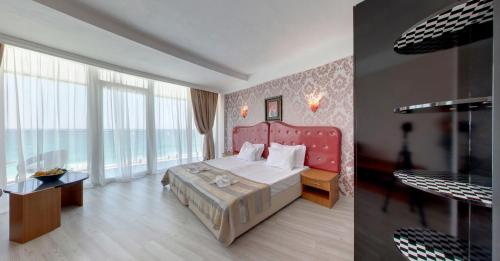 a bedroom with a large bed with a red headboard at SPA Hotel Sirius Beach - FREE SPA access in St. St. Constantine and Helena