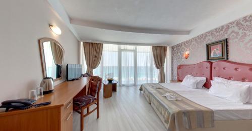 a hotel room with a large bed and a television at SPA Hotel Sirius Beach - FREE SPA access in St. St. Constantine and Helena