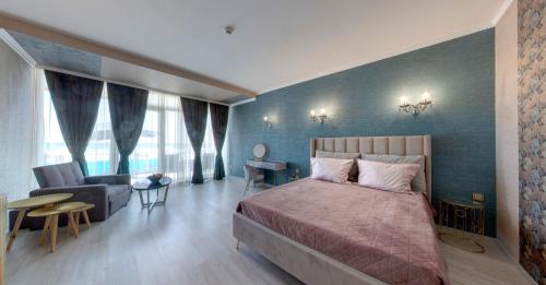 a bedroom with a bed and a couch and a chair at SPA Hotel Sirius Beach - FREE SPA access in St. St. Constantine and Helena