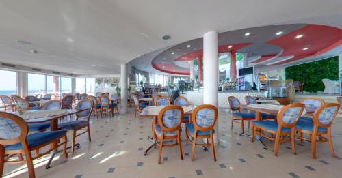 a restaurant with tables and chairs and a bar at SPA Hotel Sirius Beach - FREE SPA access in St. St. Constantine and Helena