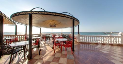 a patio with tables and chairs and the ocean at SPA Hotel Sirius Beach - FREE SPA access in St. St. Constantine and Helena