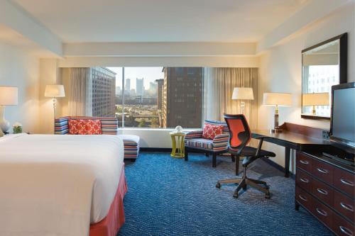 ボストンにあるルネッサンス ウォーターフロント ホテルのベッド、デスク、テレビが備わるホテルルームです。